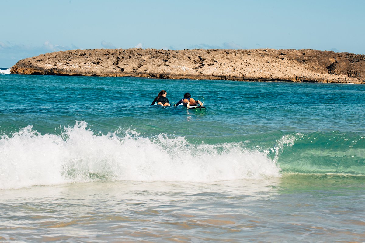 Dos surfistas disfrutan de Playa Jobos en Isabela.