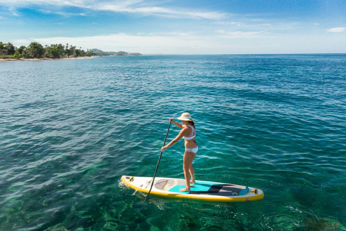 A woman enjoys stand-up paddleboarding in clear waters near Rincon.