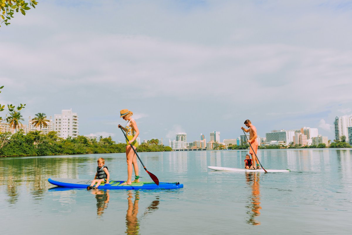 Una familia practica paddleboarding en la laguna de Condado.