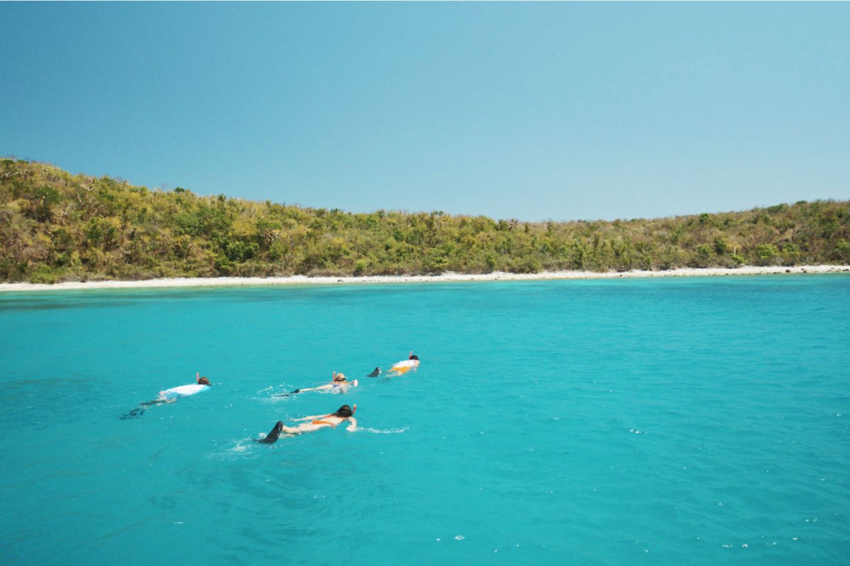 Un grupo de personas bucea con tubo en aguas turquesas y claras en la playa Flamenco en Culebra.
