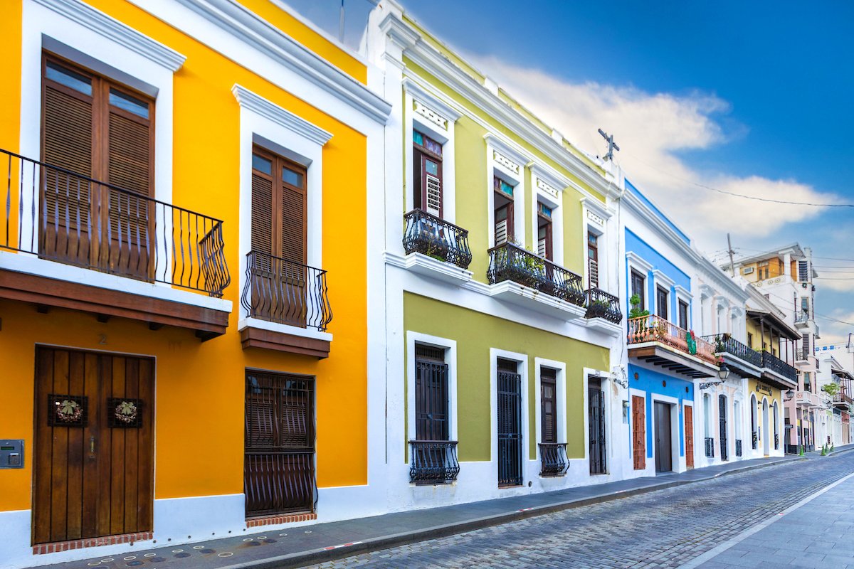 Edificios amarillos, verdes y azules bordean las calles empedradas del Viejo San Juan.