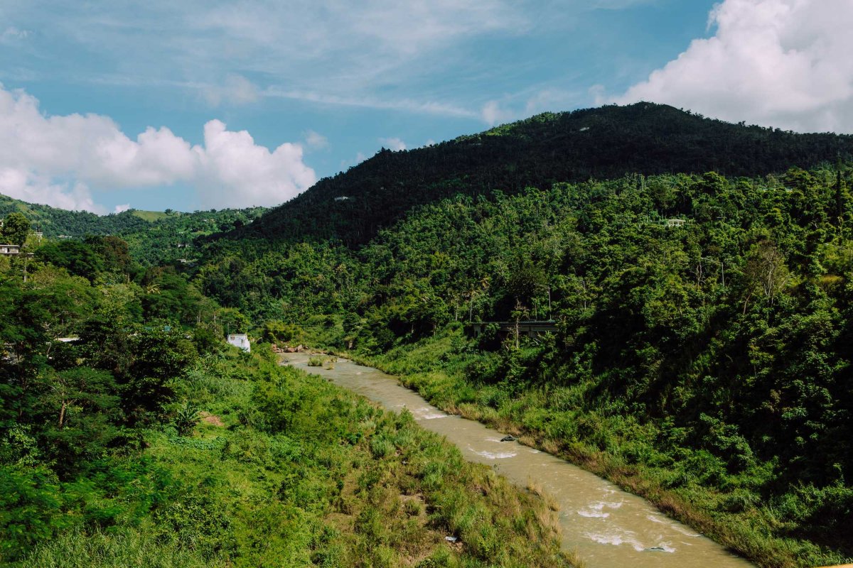 A river runs through a hilly, green countryside in Comerío, Puerto Rico.
