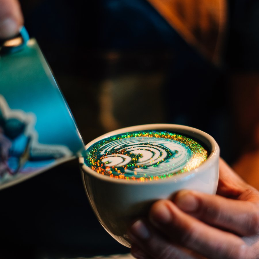 Un barista prepara una bebida de café elaboradamente decorada en Bistro Cafe en Carolina.