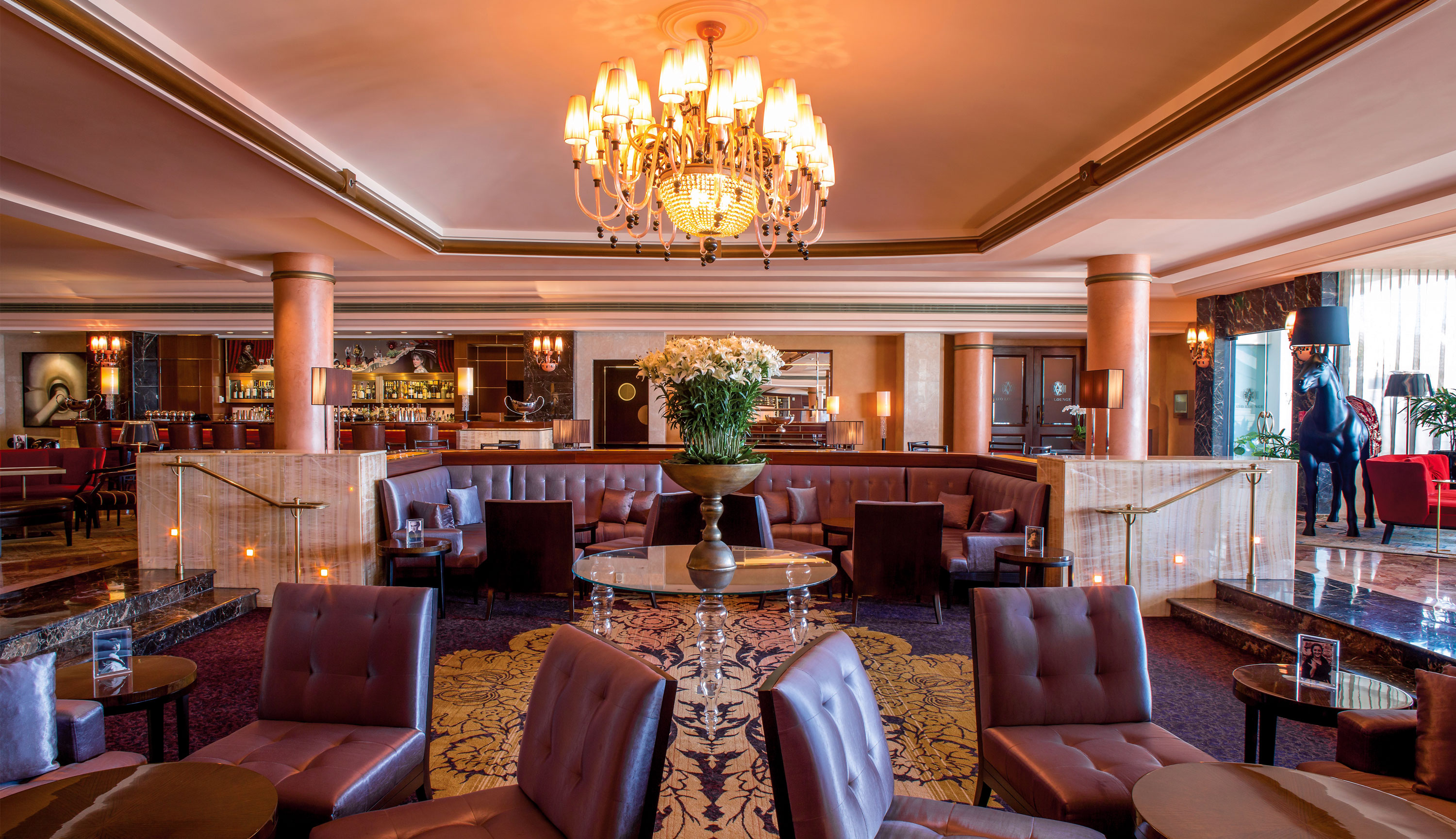 The elegant lounge at the Condado Vanderbilt hotel includes leather upholstery, marble columns and an ornate chandelier.