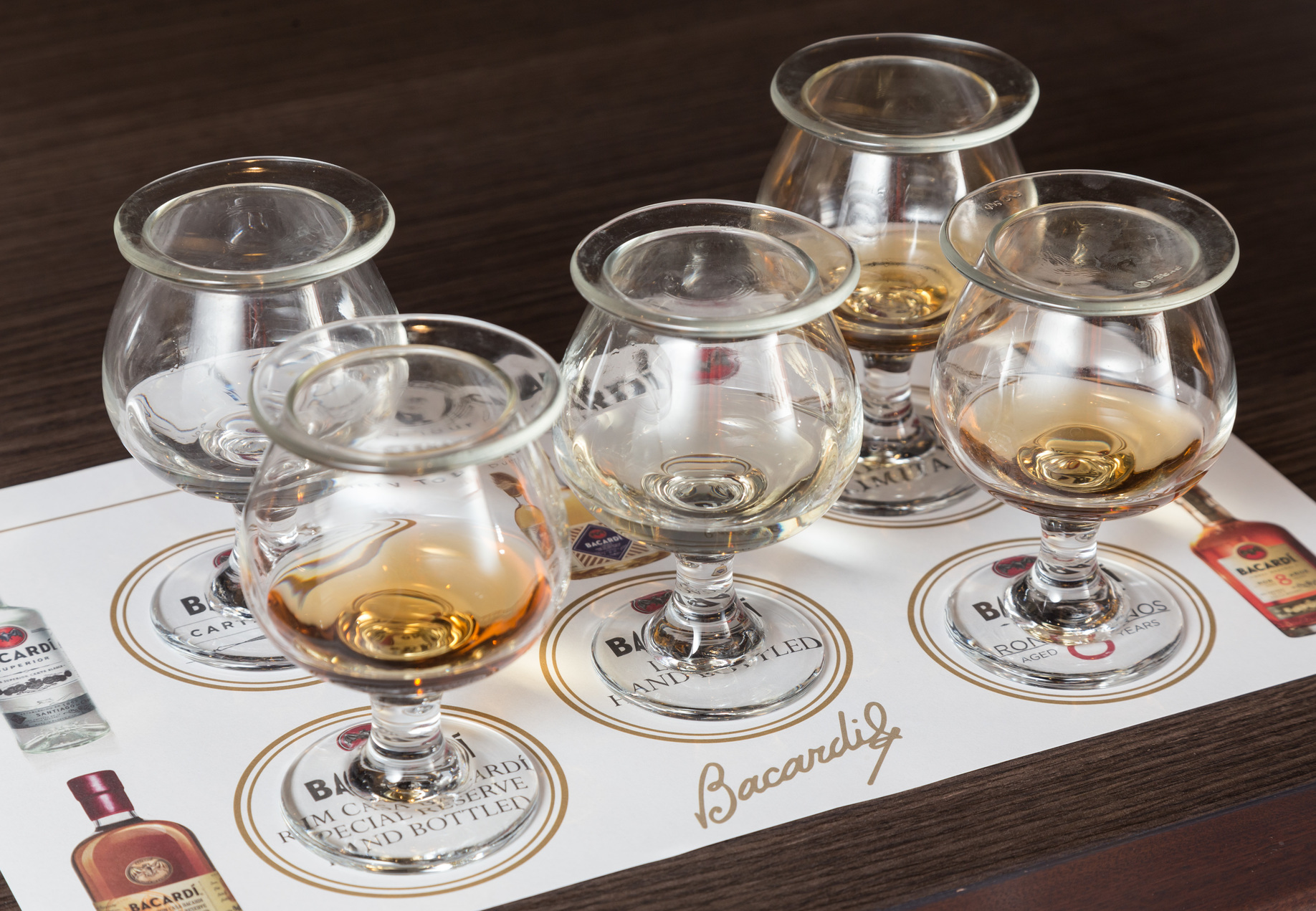 five tasting glasses with different types of rum lined up at casa bacardi