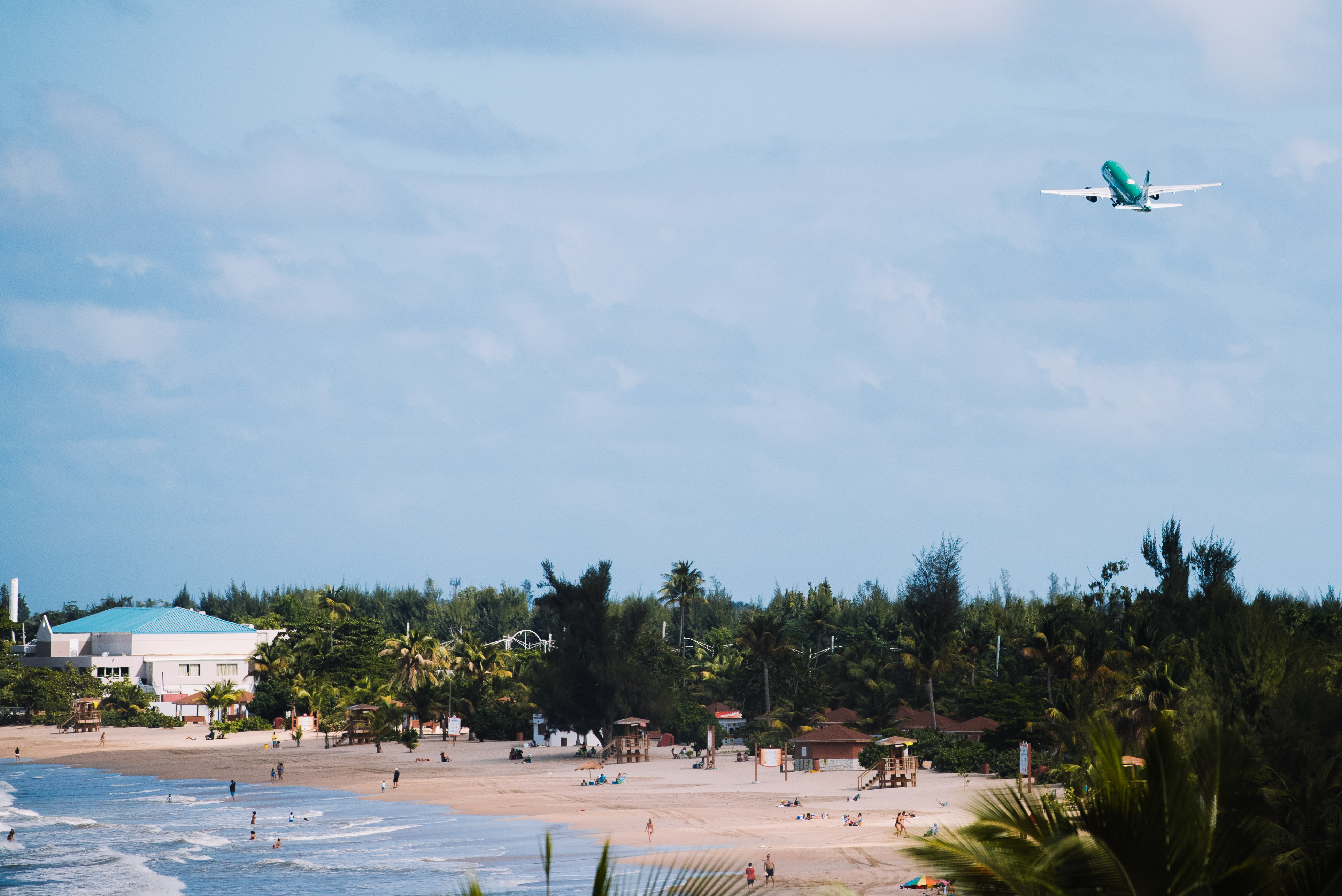 Airplane flying over the beach near Isla Verde Airport.
