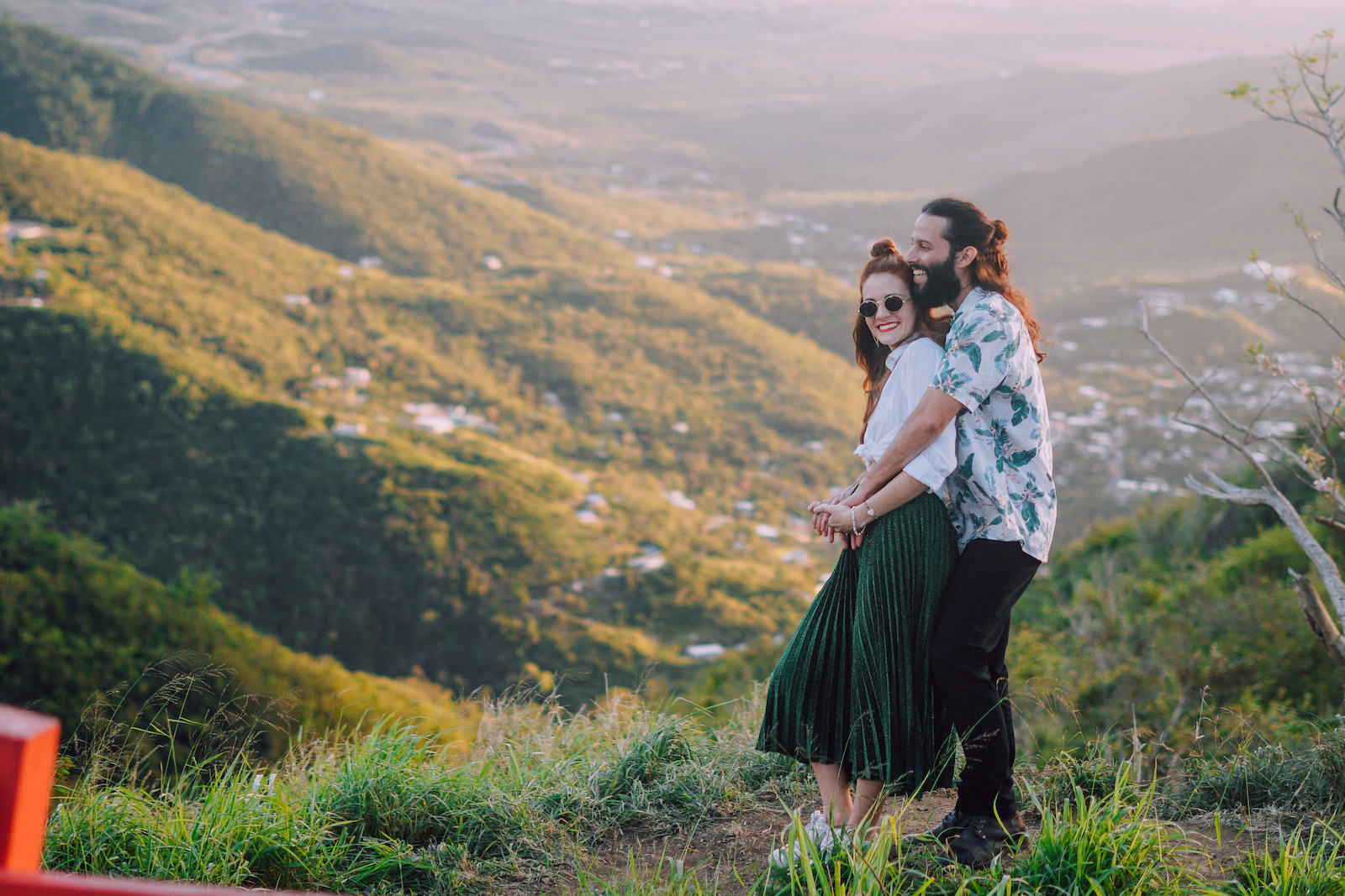 A couple embraces above a gorgeous mountain valley.