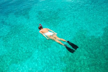 A woman enjoying vibrant turquoise waters while snorkeling in Puerto Rico.