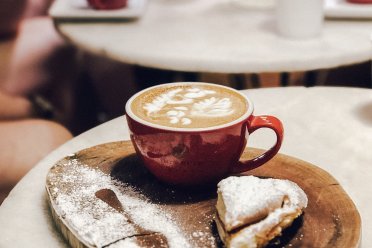 Traditional Puerto Rican mallorca pastry dusted with powdered sugar, served with a cup of local coffee.