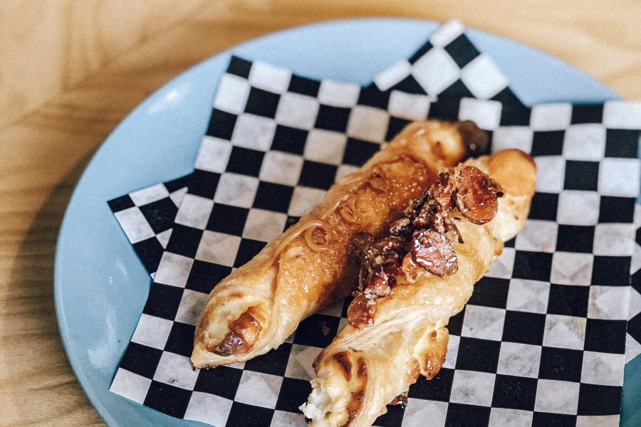 Flaky Puerto Rican pastry filled with sweet cream cheese, known as quesito, on a bakery plate.