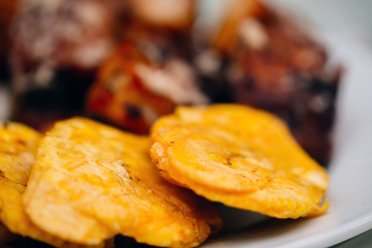 Tostones crujientes, un aperitivo tradicional de la comida puertorriqueña preparado con plátanos verdes fritos.