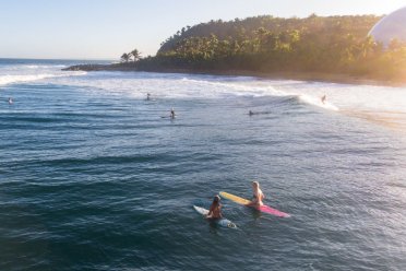 Surfers paddle out to catch a wave at Domes Beach in Rincon, Puerto Rico.