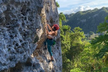 Woman climbing karstic rock.