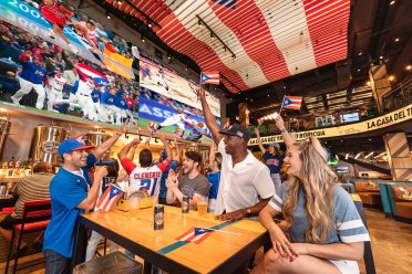 Un grupo celebra al equipo de béisbol de Puerto Rico en el salón Arena Medalla en el Distrito T-Mobile.