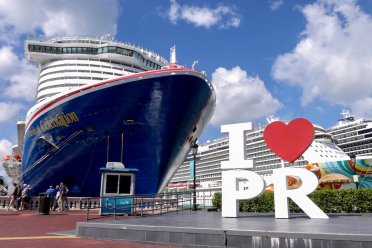 The "I Love PR" sign in front of a large cruise ship at the Old San Juan Port.