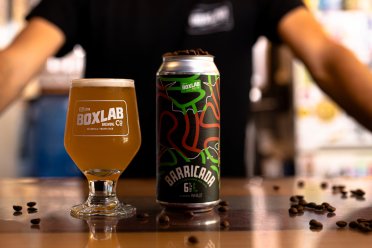 A glass of beer and can of Box Lab Beer