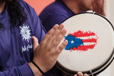 Musician playing a pandero during a traditional Puerto Rican plena performance, a rhythmic folk music style known as “the newspaper of the people.”