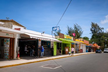 Colorful food kiosks at the Kioskos de Luquillo on Puerto Rico’s east coast, with people visiting local restaurants along the roadside.