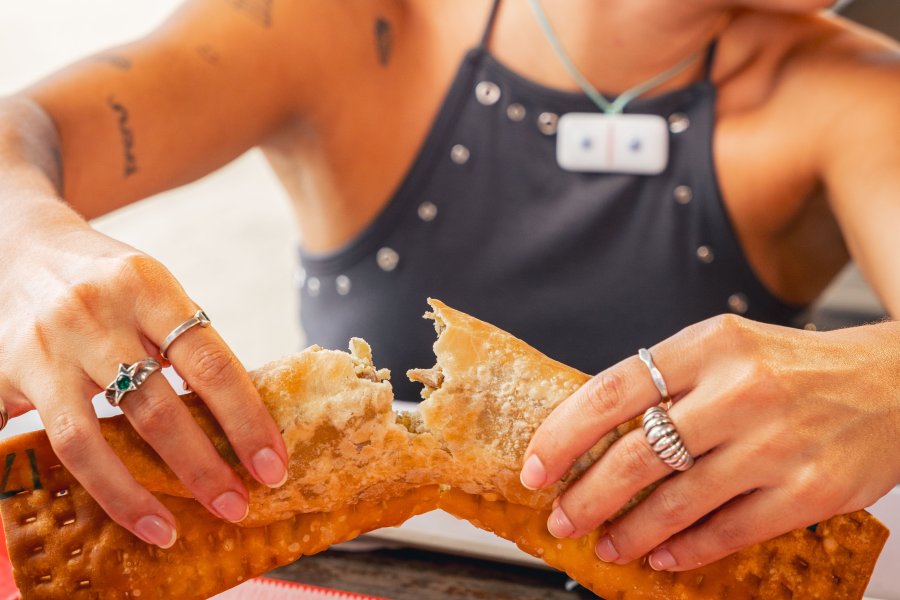 Bianca Montoya breaks open a large crispy pastelillo during a food stop in Guayama, Puerto Rico.