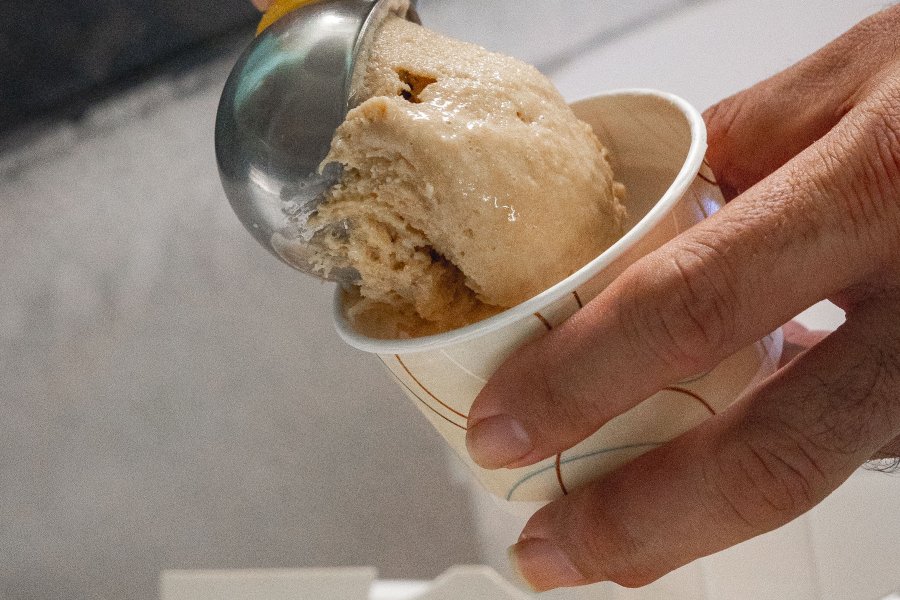 A scoop of coffee ice cream is served into a cup at a local ice cream shop in Lares, Puerto Rico.