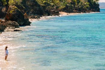 A woman admires the aquamarine waters of Wishing Well beach in Aguadilla. 