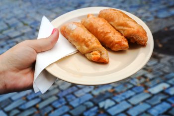 A woman's hand holding a plate with quesitos.