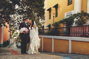 A bride and groom kiss on a cobblestone street in Old San Juan, Puerto Rico.