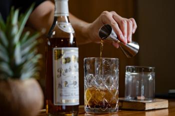 A bartender pours a shot of Ron del Barrilito into a glass