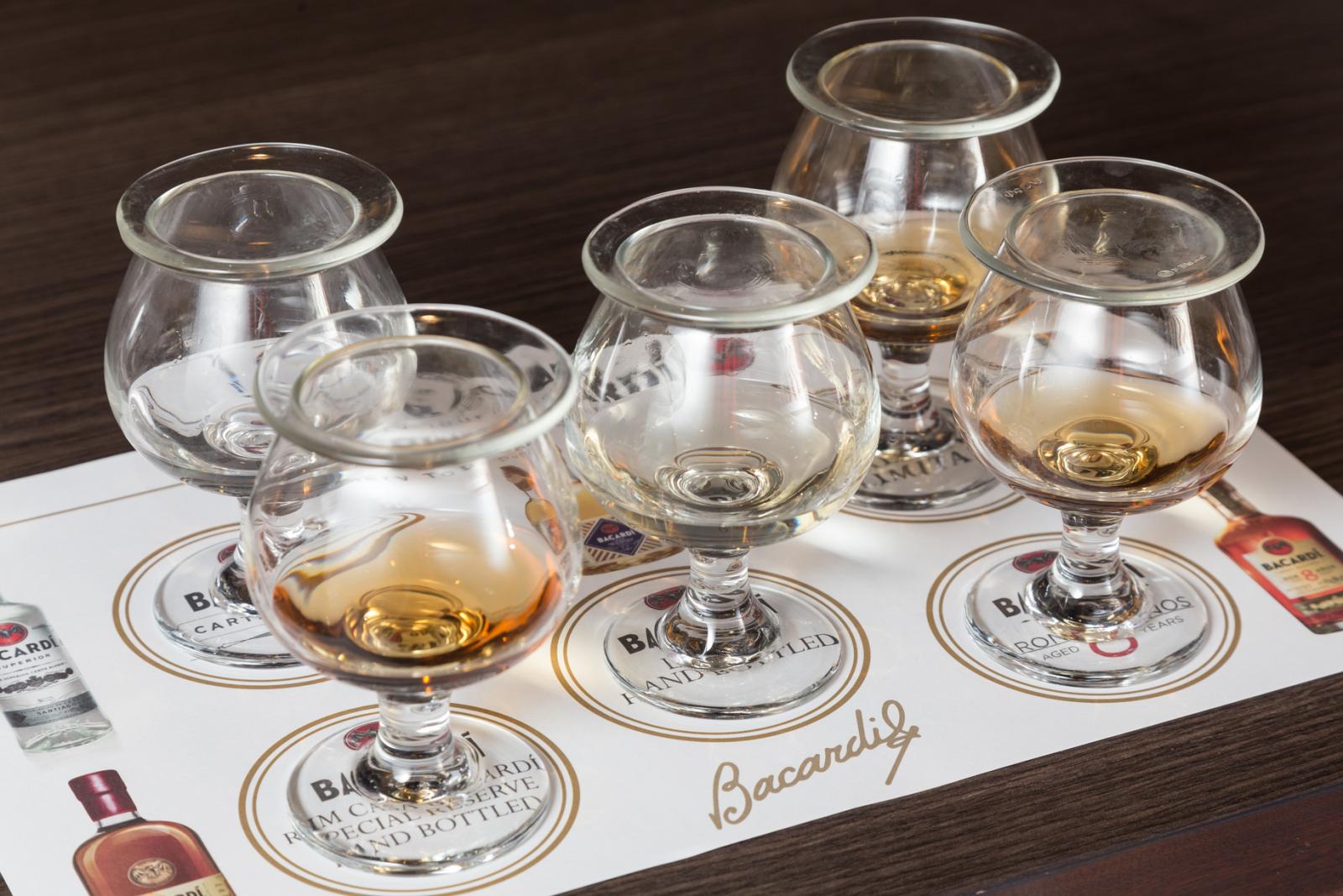 five tasting glasses with different types of rum lined up at casa bacardi
