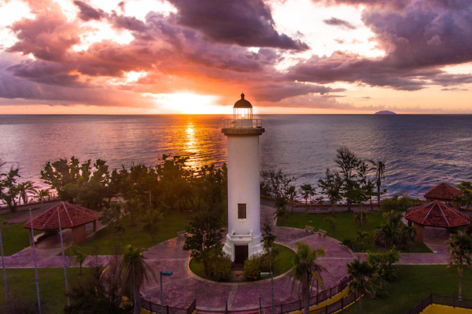 The sun sets behind a lighthouse in Rincón.