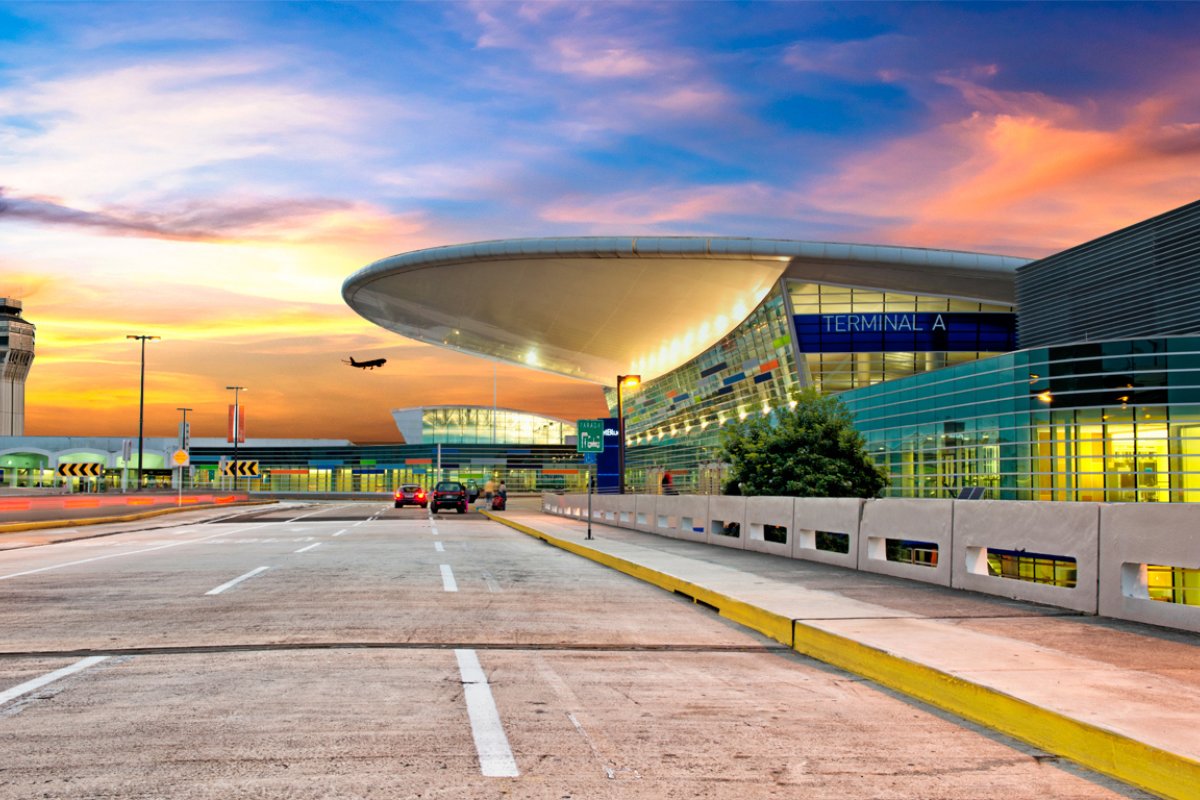 A colorful sky is visible behind the modern designed terminal building of the Luis Munoz International Airport near San Juan