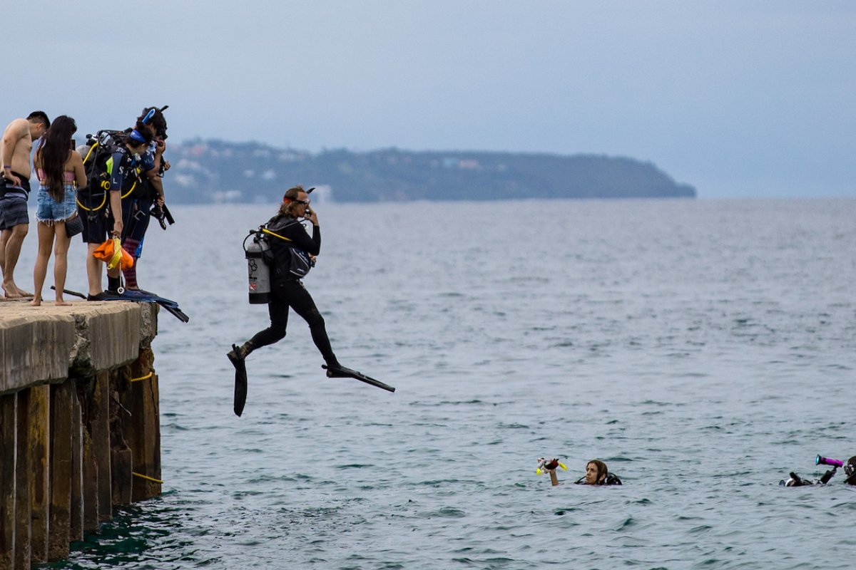 Dive instructor jumps into ocean at Crash Boat Beach.