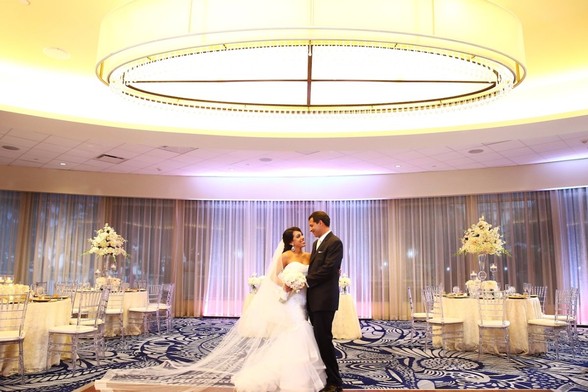 A couple embraces in a gorgeous ballroom.
