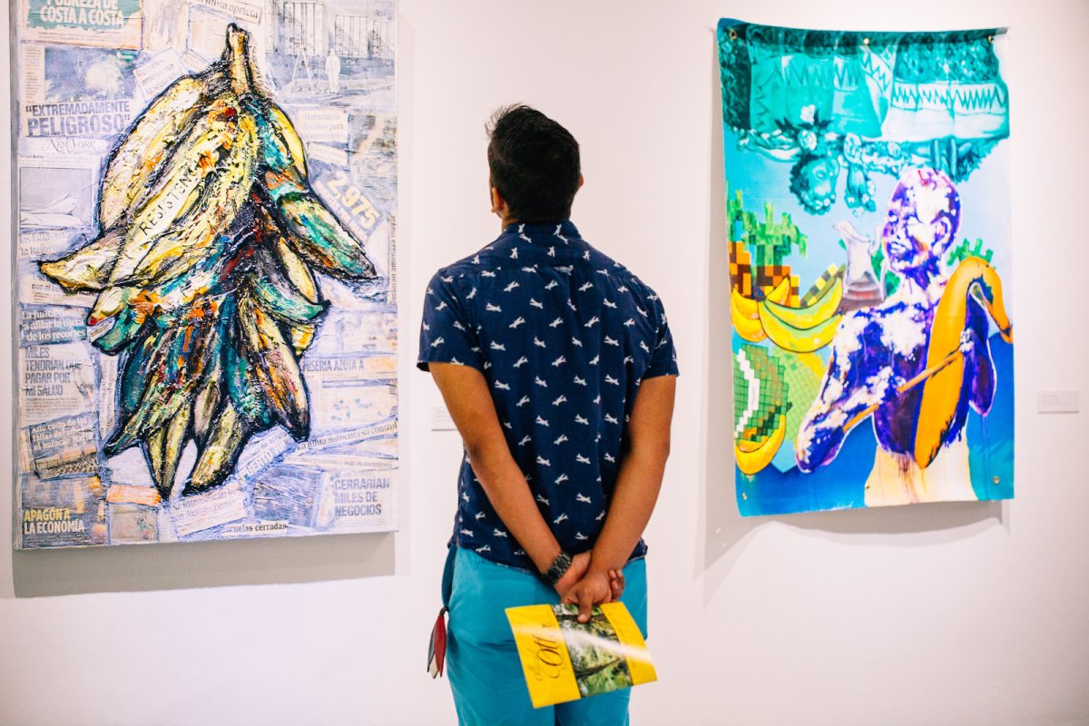 A visitor admires the work of impressionist artist Francisco Oller.