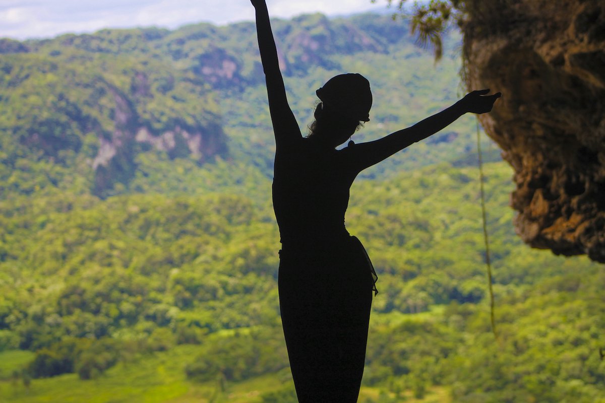 A women stands in the opening of Cueva Ventana.
