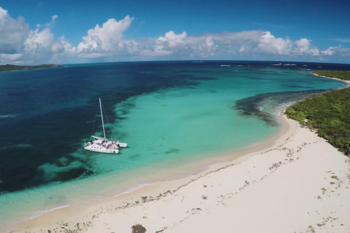 a sailboat idles near Icacos islet. 