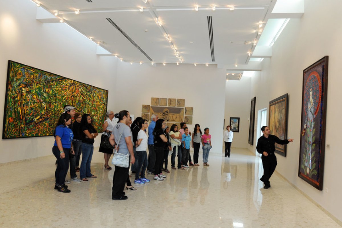 A tour guide leads a group at an art museum in Bayamon.