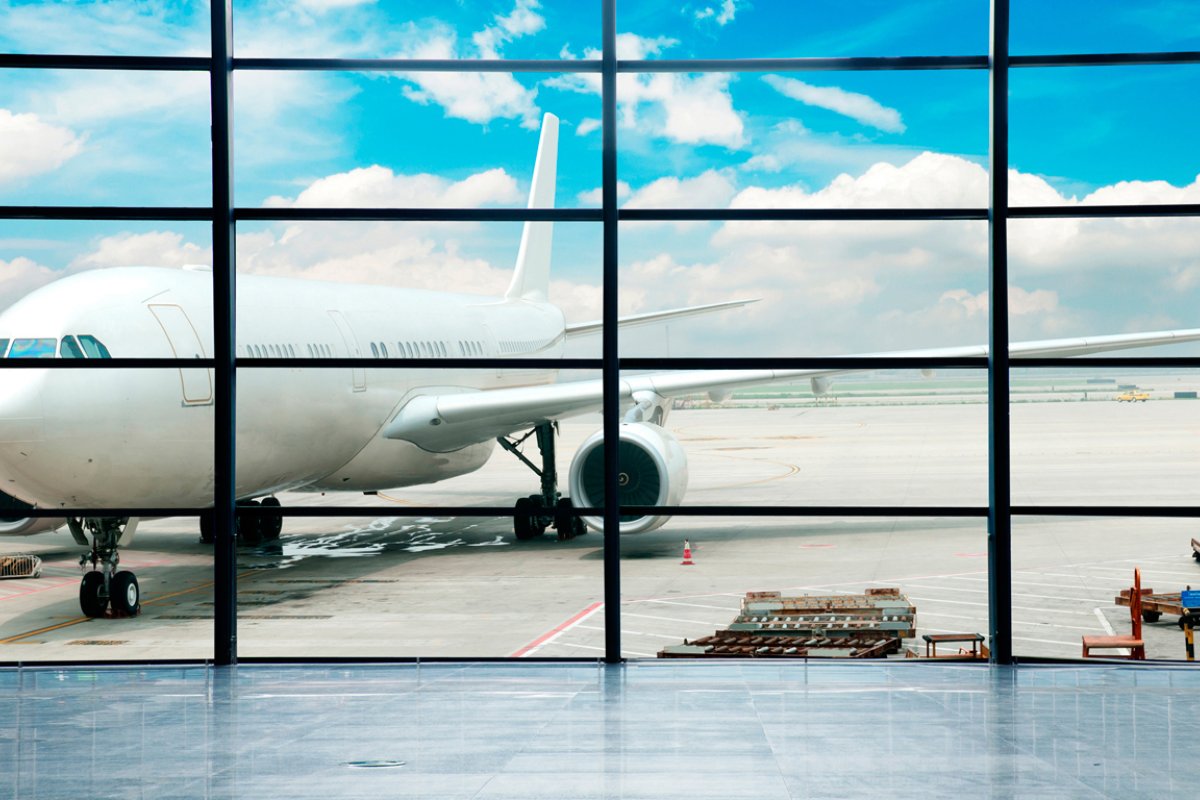 An airplane on runway viewed through the windows from the inside of the airport in San Juan.