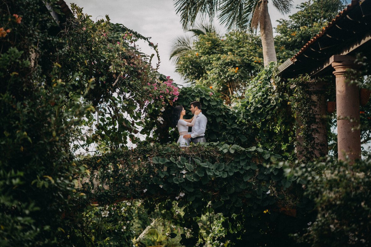 Couple standing on an ivy-covered bridge at Hacienda Siesta Alegre. 