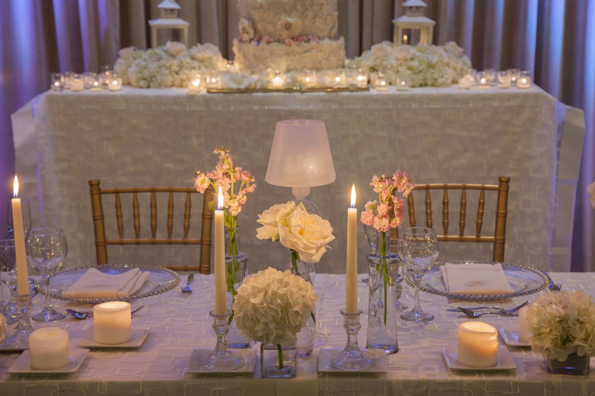 Una mesa de recepción de bodas iluminada con velas.