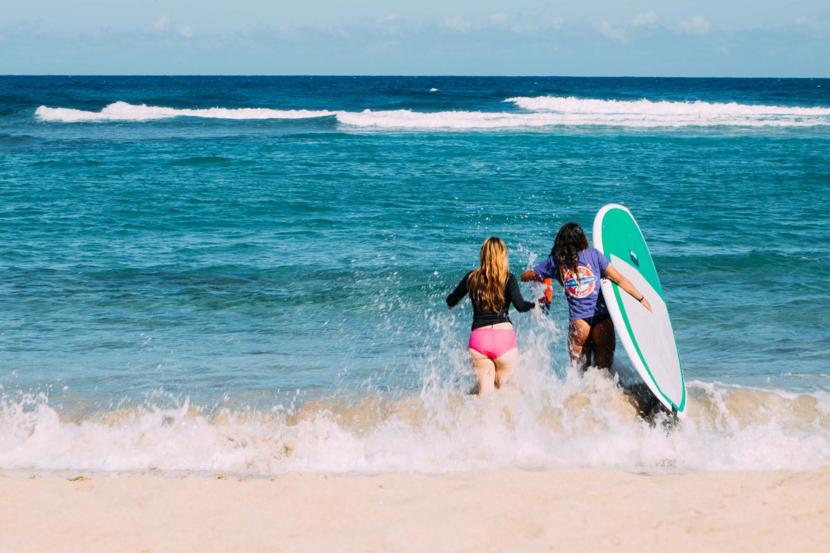 Two women run through the waves at Jobos Beach in Isabela. 