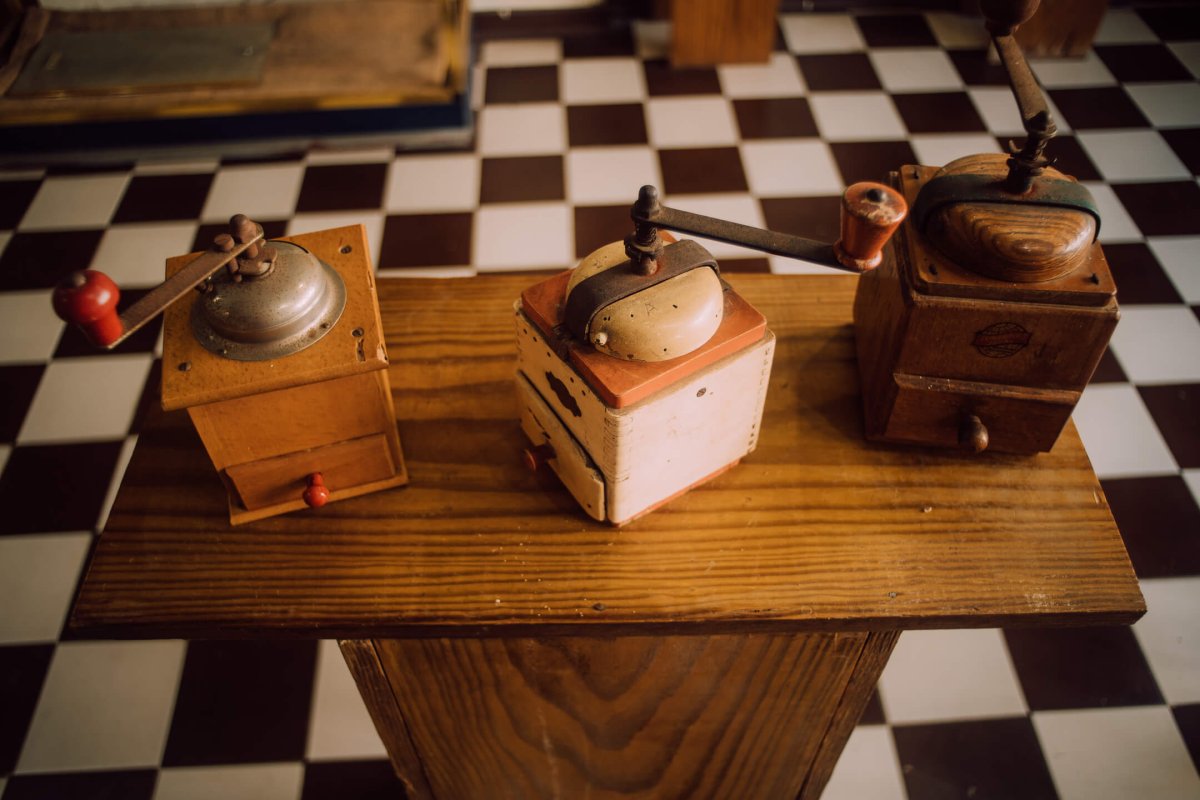 Coffee grinders sitting on a wooden table. 