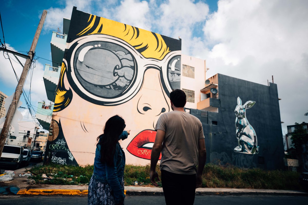 Dos personas admiran los murales en Santurce.