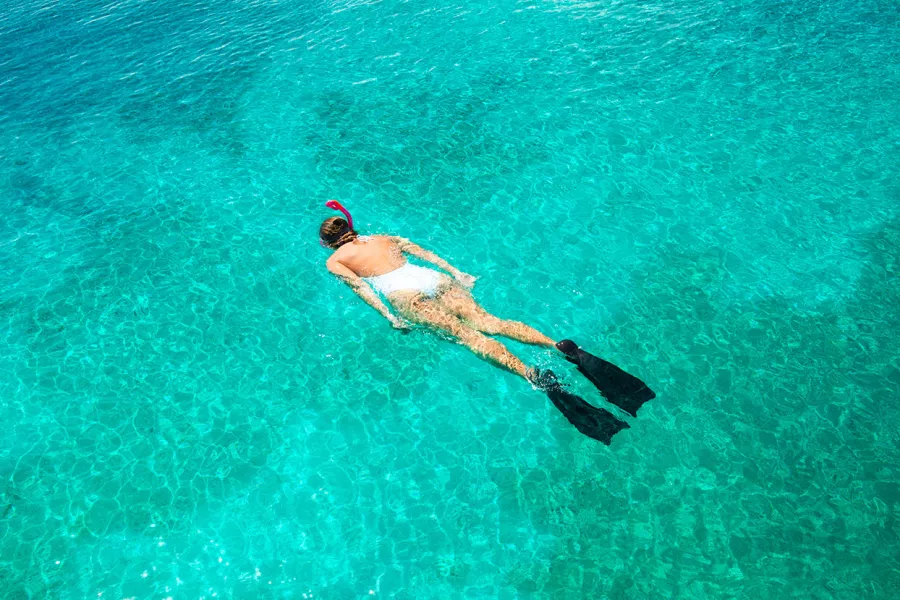A woman enjoying vibrant turquoise waters while snorkeling in Puerto Rico.