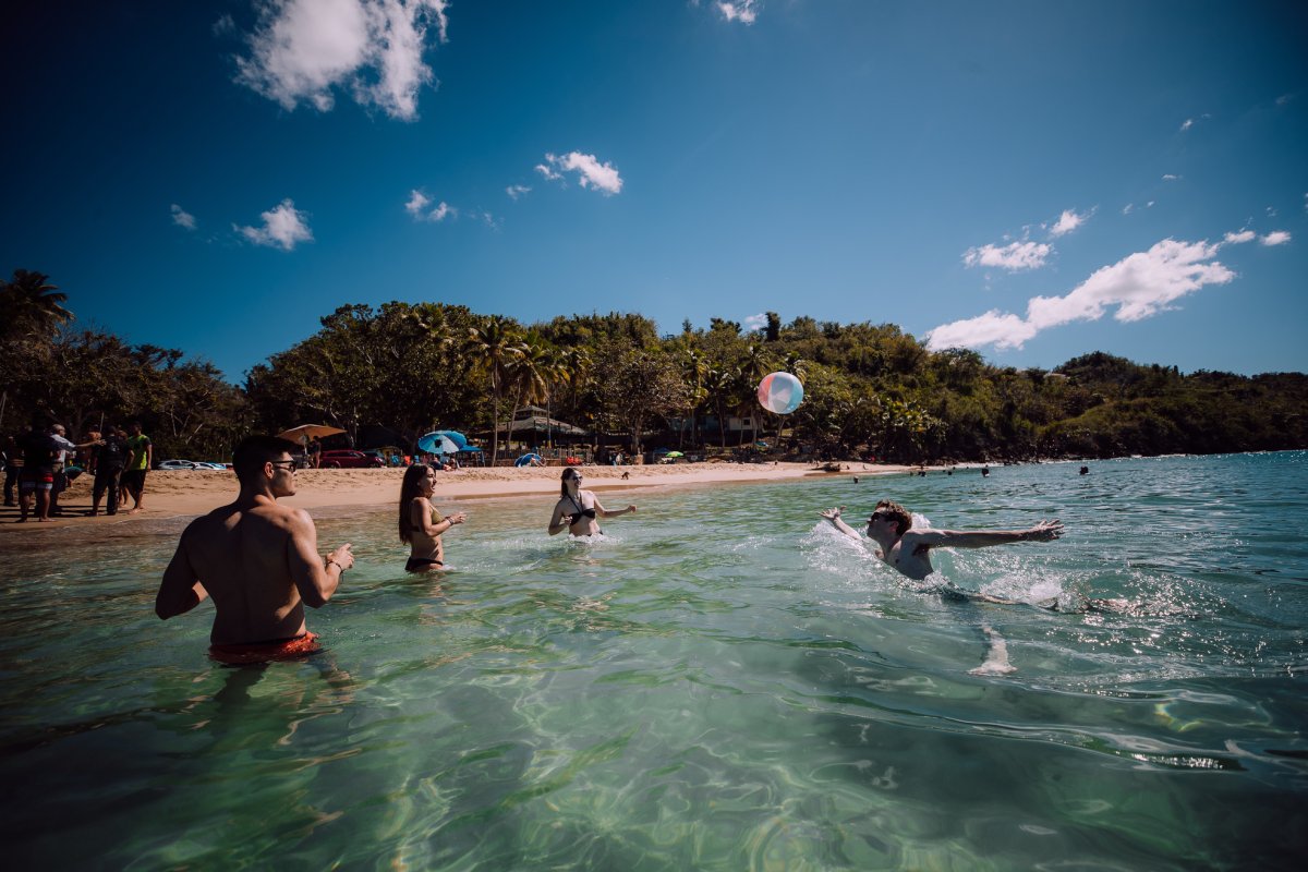 A group of friends plays with a ball at Crash Boat Beach in Aguadilla.