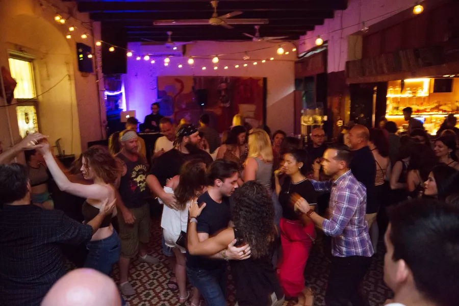 Personas bailando salsa en La Factoría, un icónico local de Puerto Rico.