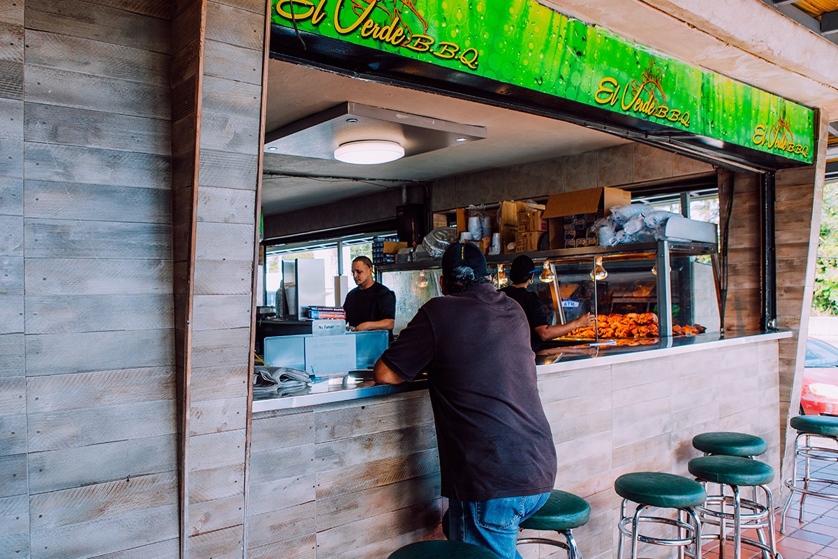 Locals sit around El Verde BBQ and savor staple dishes