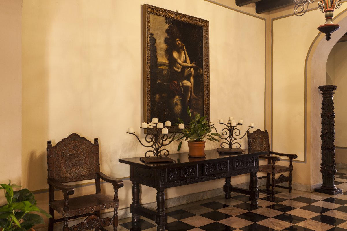 A historic painting hangs on a wall inside el convento hotel