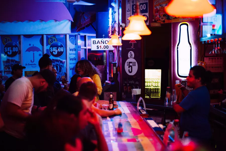 Ambiente animado en La Sombrilla Rosa, bar icónico de la vida nocturna en San Juan.
