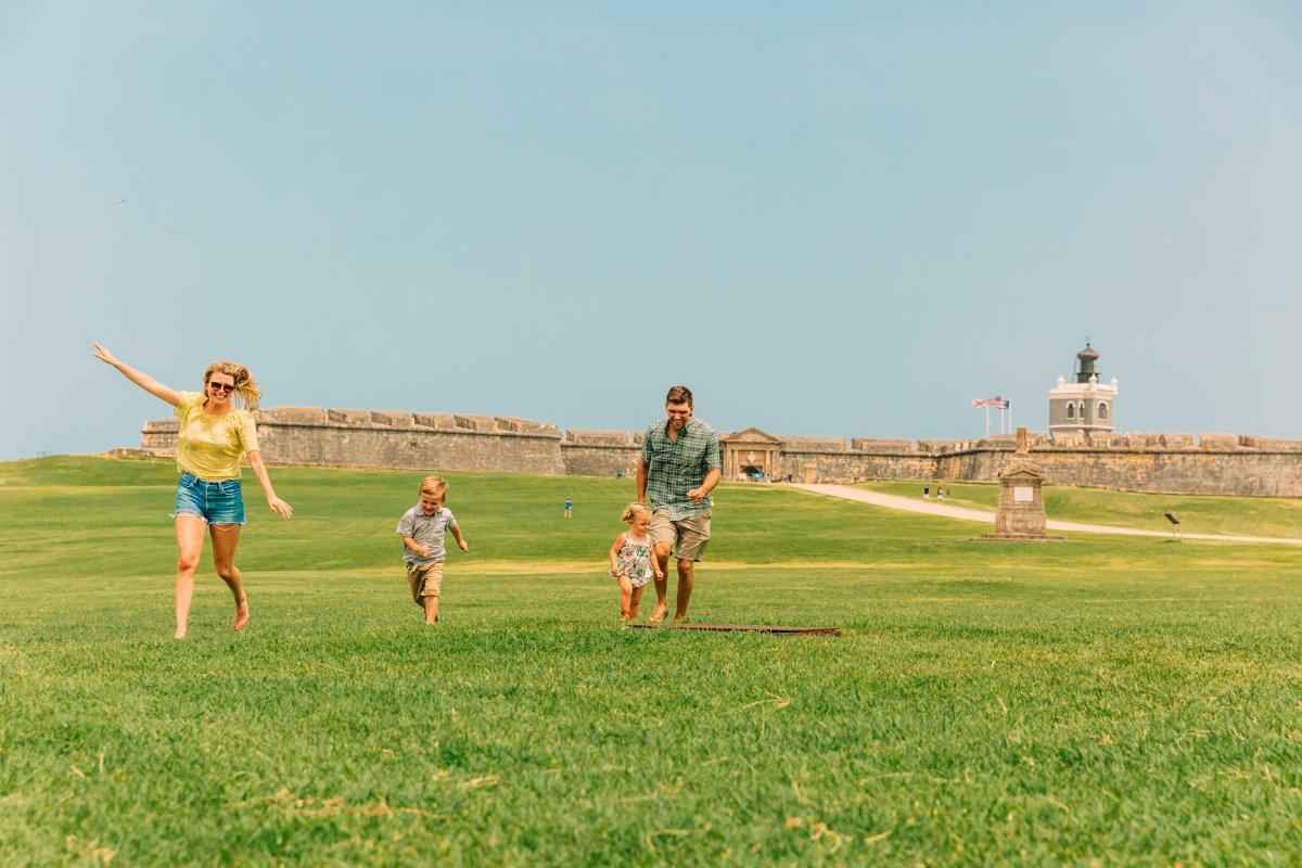 Kids run around the lawn at El Morro